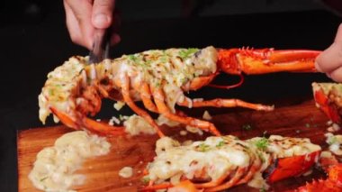 Pişmiş ıstakozu spagetti ve sebzelerin yanına koyan bir şef.