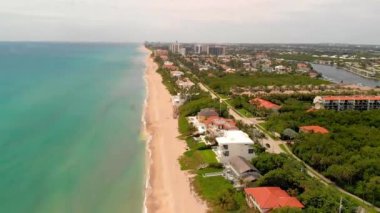 Denizdeki bulutlu gökyüzünün, kumlu kumsalın ve Güney Florida 'daki sahil kasabasının insansız hava aracı görüntüleri.