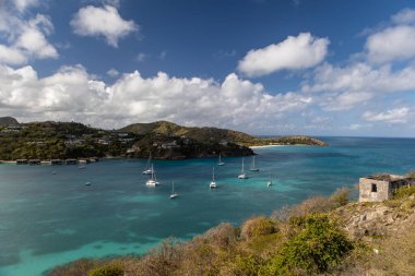 Derin Körfezin Bluewater sahnesi Fort Barrington, Antigua ve Barbuda 'dan bulutlu bir gökyüzü ile büyüleyici.