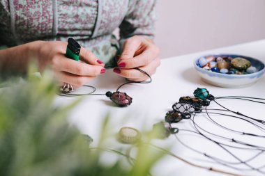 Kadın eli, el yapımı mücevher, ev yapımı atölye. Kadın esnaf mücevher üretir. Sanat, hobi, el işi konsepti