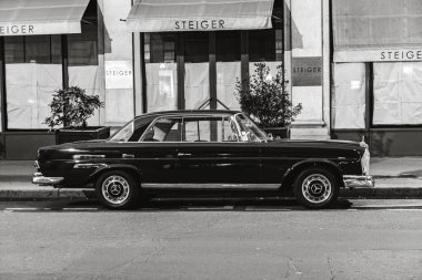 Mercedes Benz W111 'in gri tonlu resmi. Paris, Fransa' da sokağa park edilmiş klasik lüks araba.
