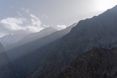 Zirvelerden süzülen güneş ışığıyla güzel bir dağ manzarası