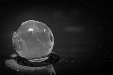 Bulanık arkaplandaki su boncuğunun gri tonlu görüntüsü