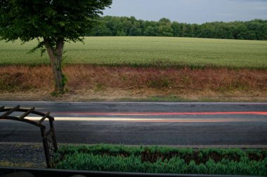 Bulanık ışık, hareket halindeki araba akşamının saha kenarında olduğunu gösteriyor.