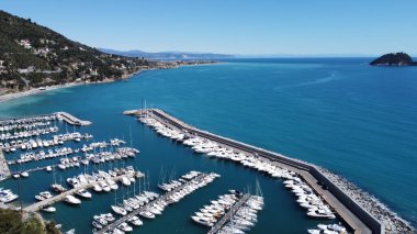 İtalya 'da Alassio sahilinde açık gökyüzü olan tekne ve rıhtımlar.