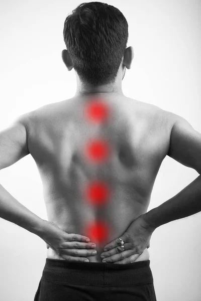 body pain, backache, spine injury. shirtless man holding at back pain point red highlight glow on spine in white background