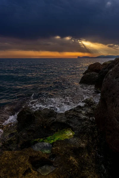 Vertical Shot Waves Reaching Rocky Shore Sunset Sky Bright Sunbeams — Stock Photo, Image