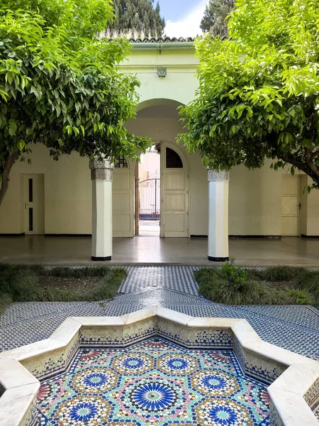 Empty mosaic courtyard with a small fountain in the middle