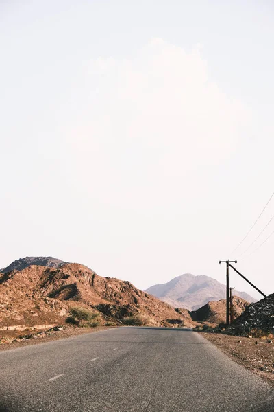 Вертикальный Снимок Длинной Пустой Дороги Протянувшейся Через Песчаные Холмы Дневное — стоковое фото
