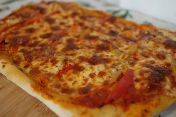 一张西西里披萨片的特写照片在一个背景模糊的木制餐具柜上 — 图库照片