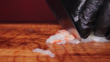 Siyah lastik eldivenli bir şefin çiğ ıstakoz etini keserken çekilmiş yavaş çekim videosu.