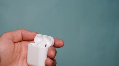 Bir adam kablosuz kulaklıkları şarj aletine takıyor.