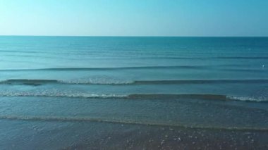 Su dalgaları kumsaldaki kumu vuruyor.