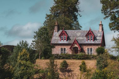 Ormanda, gün ışığının altında, İskoç tarzı güzel bir ev.