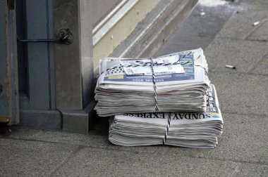 İngiltere, York 'ta kaldırımda satılmamış iki paket Sunday Express gazetesinin yakın plan çekimi.