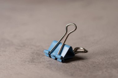 Gri bir arkaplanda izole edilmiş mavi bir kağıt parçasının yakın çekimi