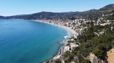 Güneşli bir yaz gününde deniz ve kıyı kasabasının büyüleyici manzarası.