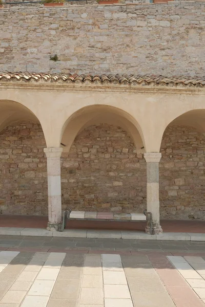 Svislý Výstřel Prázdné Lavice Mezi Oblouky Assisi Itálie — Stock fotografie
