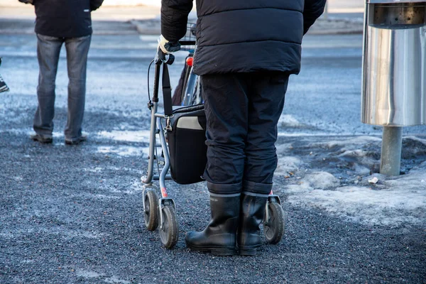 A older people walking with a rollator down the street