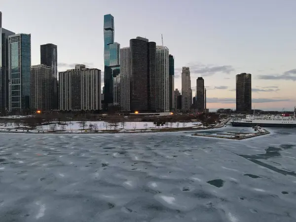 イリノイ州シカゴの日没時の凍結した川と高層ビルの空中ビュー — ストック写真
