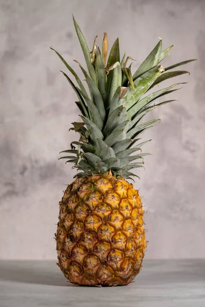 Pionowe Ujęcie Dojrzałego Ananasa Odizolowanego Szarym Tle — Zdjęcie stockowe