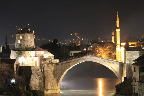 A view of lighted old bridge over the river in Mostar at the night