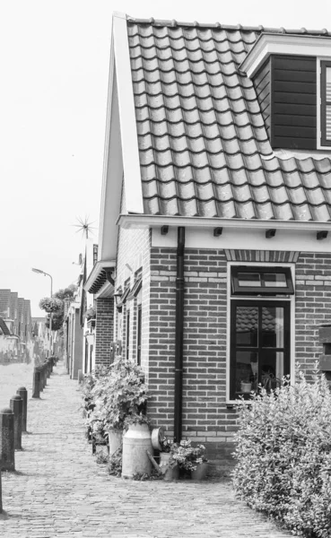 A vertical shot of a small suburban house made from bricks in grayscale