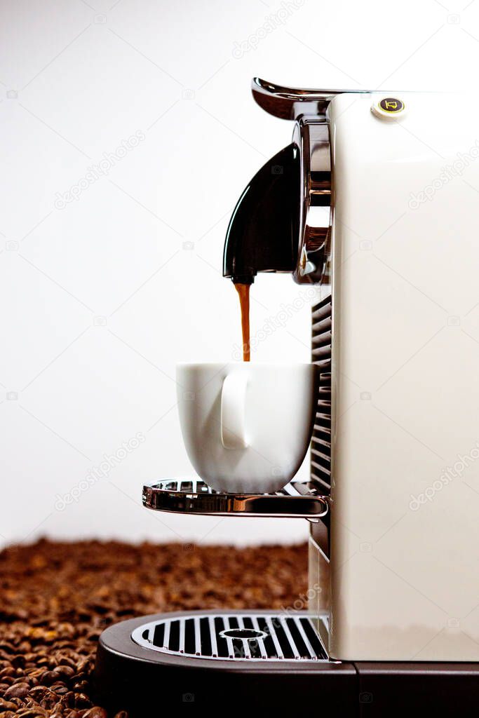 A vertical shot of coffee beans surrounding a coffee making machine