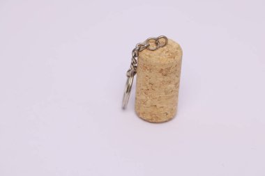 Bir şarap mantar anahtarlığının yakın plan görüntüsü, kopyalanmış beyaz bir arkaplanda izole edilmiş.