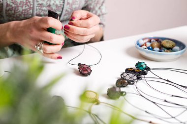 Kadın eli, el yapımı mücevher, ev yapımı atölye. Kadın esnaf mücevher üretir. Sanat, hobi, el işi konsepti