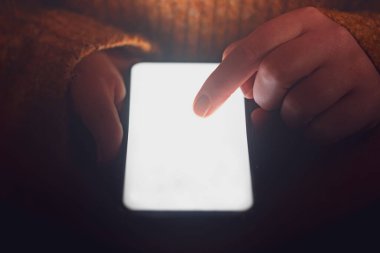 Akıllı telefonun ekranına dokunan bir parmağın yakın çekim görüntüsü. İçeriğiniz için yer var.