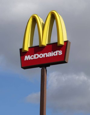 İngiltere 'deki Peterborough hizmetlerinde McDonald' s 'ın gökyüzüne karşı dikey bir tabela görüntüsü.