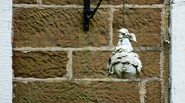 Nahaufnahme Einer Kleinen Statue Vor Einer Backsteinmauer — Stockfoto