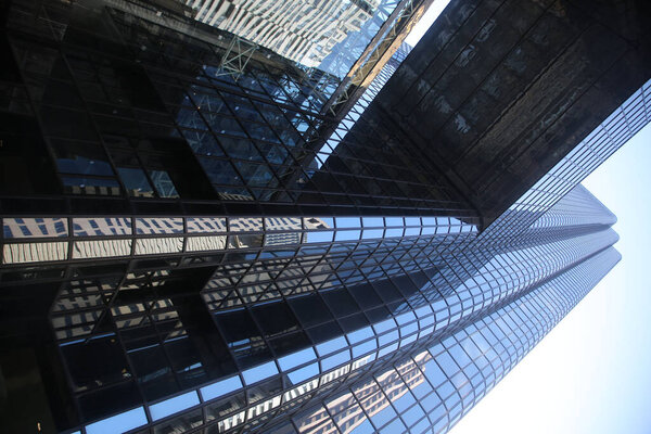 A low angle shot of a highrise building with full glass walls in the Boston Financial District