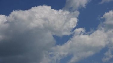 Mavi gökyüzü arka planında hareket eden güzel kabarık bulutların hızlandırılması