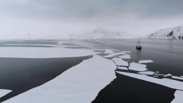 Снимок Беспилотника Лодки Замёрзшем Море Горами Спине Покрытыми Снегом Антарктиде — стоковое видео