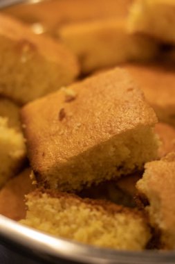 Metal bir kasede taze yapılmış mısır ekmeğinin dikey görüntüsü.