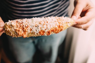 Bir dişinin elleri fırında peynir tutuyor.