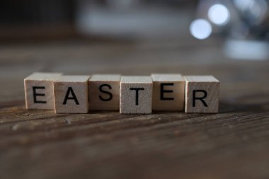 EASTER kelimesine yakın plan tahta bir yüzey üzerine tahta küplerden serilmiş.