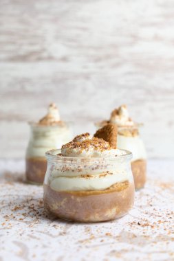 Bulanık arka planda krema, şeker ve kakaodan yapılmış bir kahvenin dikey çekimi.