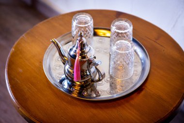 Gümüş çaydanlık ve cam çay fincanlarının doğu çay içme şeklinin keyfini çıkarmak için yakın plan çekimi.