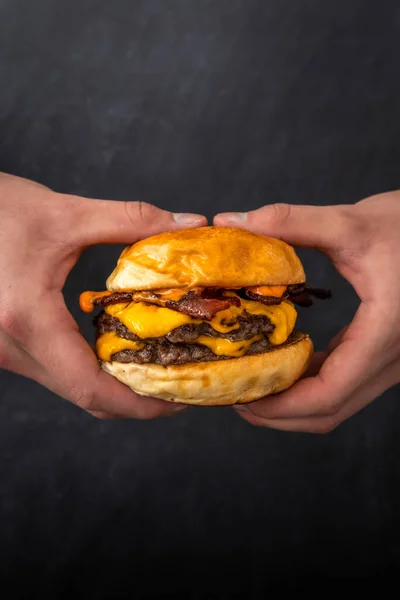 Lodret Skud Hænder Holder Lækker Saftig Burger Med Tredobbelt Patty - Stock-foto