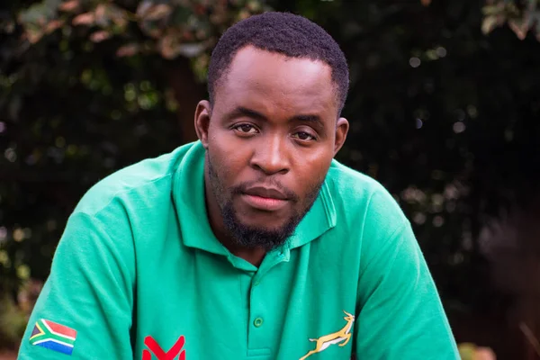 Sitting Adult Black Man Green Shirt Zimbabwe Flag Looking Camera — Stock Photo, Image