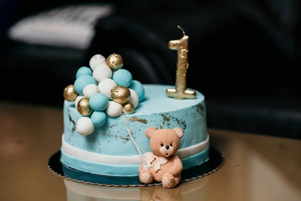 一个蓝色的生日蛋糕 上面有金色的 头号蜡烛 装饰着小熊和球 — 图库照片