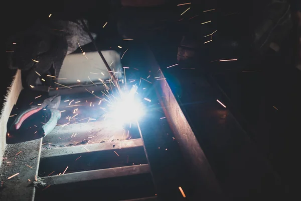 A process of arc welding for car assemble with sparks in the dark