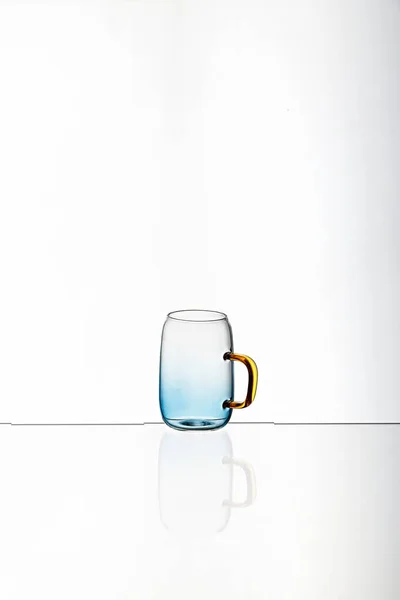 白い背景を持つガラスの青の透明カップの垂直ショット — ストック写真