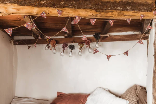 木製のトップと装飾が施された電球付きの部屋のベッドの上の3つの枕 — ストック写真