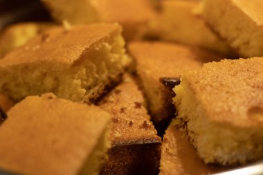 Metal bir kasede taze yapılmış mısır ekmeğinin yakın plan fotoğrafı.