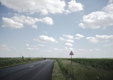 Kırsal kesimde tehlikeli bir yol tabelası olan bir yol.