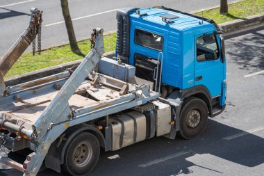 Lizbon, Portekiz 'deki moloz konteynırlarını üreten, toplayan ve taşıyan bir kamyonun manzaralı bir görüntüsü.